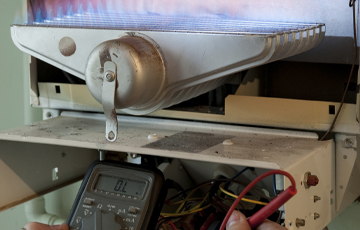 Gas engineer repairing boiler operational faults