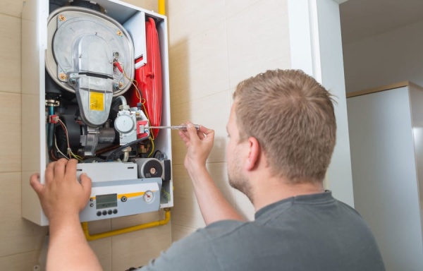 Engineer diagnosing and repairing domestic boiler