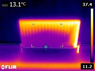 Thermal camera view comparing radiator temperature before and after power flushing